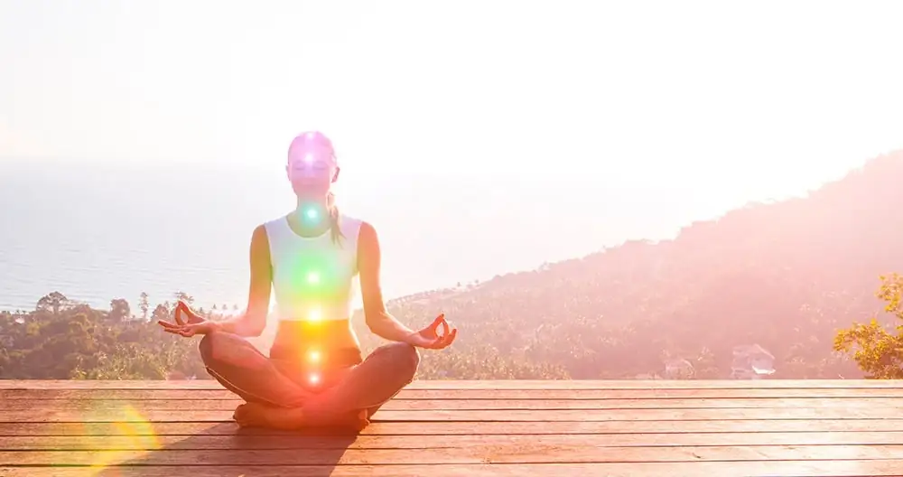 Frau in Meditation mit ausgerichteten Chakren, um je nach Energiebedarf ein Symbol der heiligen Geometrie auszuwählen