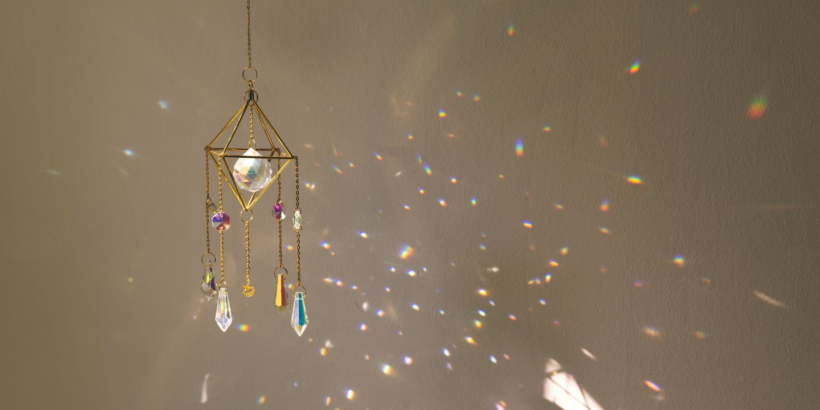 Los atrapasoles suspendidos proyectan halos de luz de colores sobre la pared interior