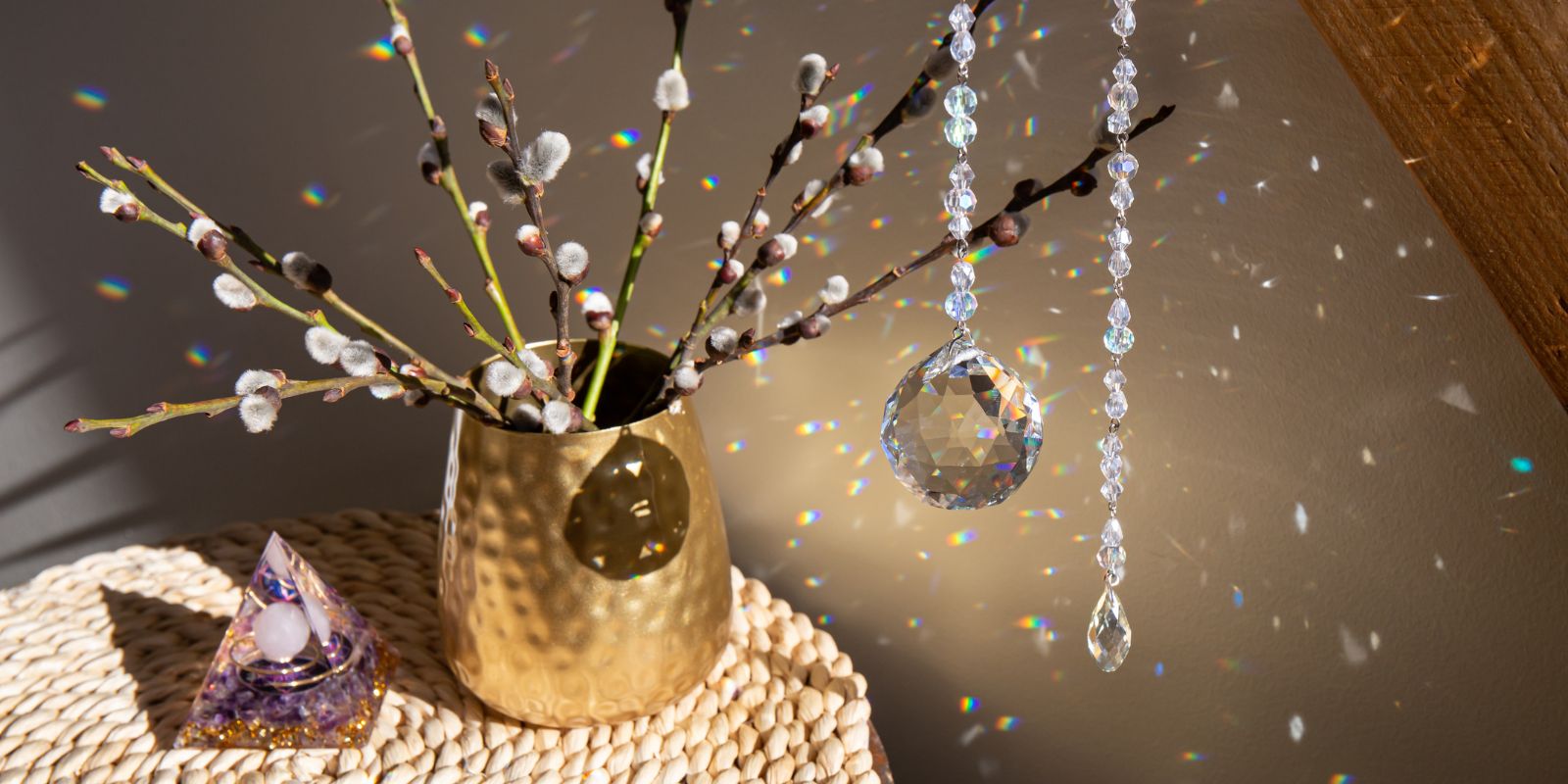 Cristal y pirámide de orgonita creando halos luminosos en la habitación, junto a un jarrón decorativo