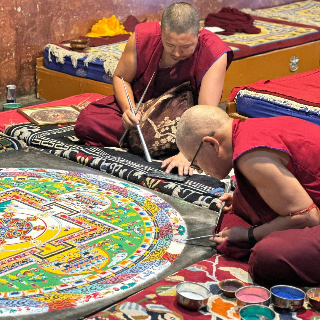 Monjes budistas trabajando en un mandala de arena que expresa el simbolismo del círculo y los ciclos del mundo natural