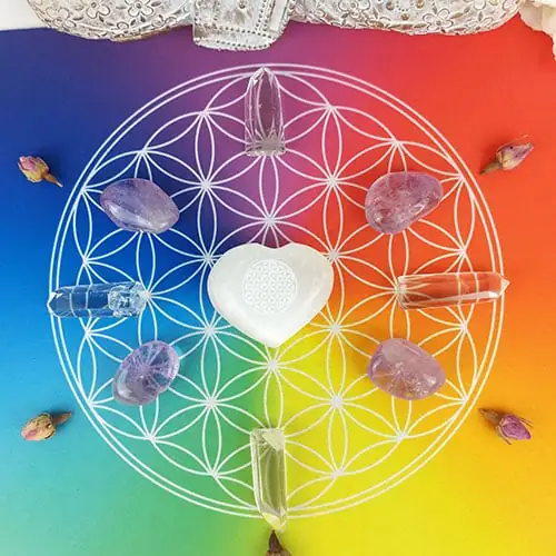 Piedras dispuestas sobre un tapete armonizador Flor de la Vida, utilizado para amplificar energías y equilibrar los chakras