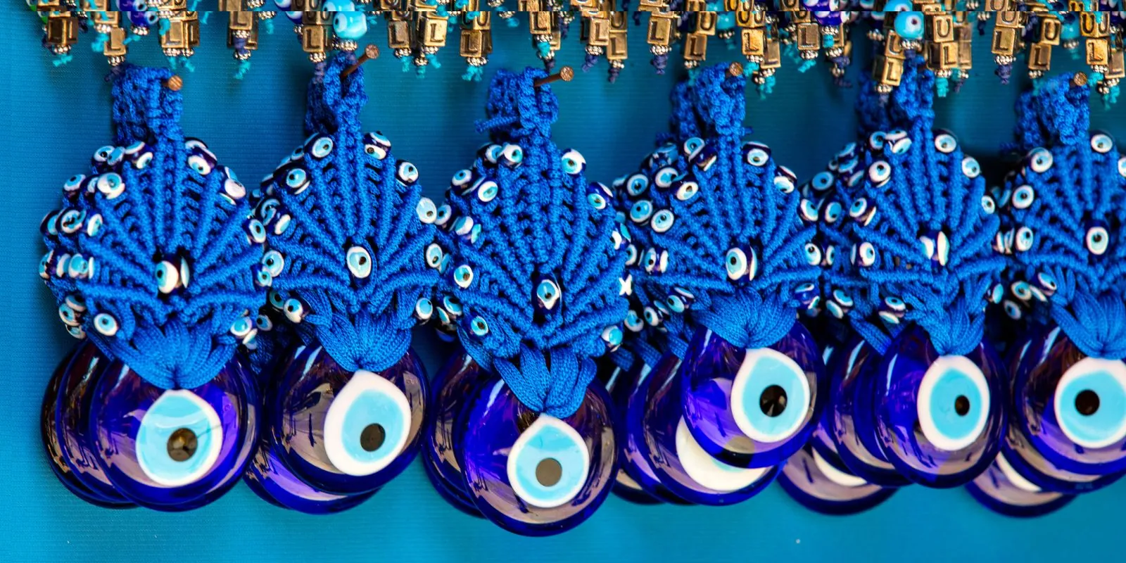 Œils bleus en verre avec attache en macramé finement tressé, exposés dans une boutique ésotérique ou artisanale
