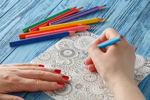Woman coloring mandalas, using creativity to promote relaxation, reduce stress, and promote well-being