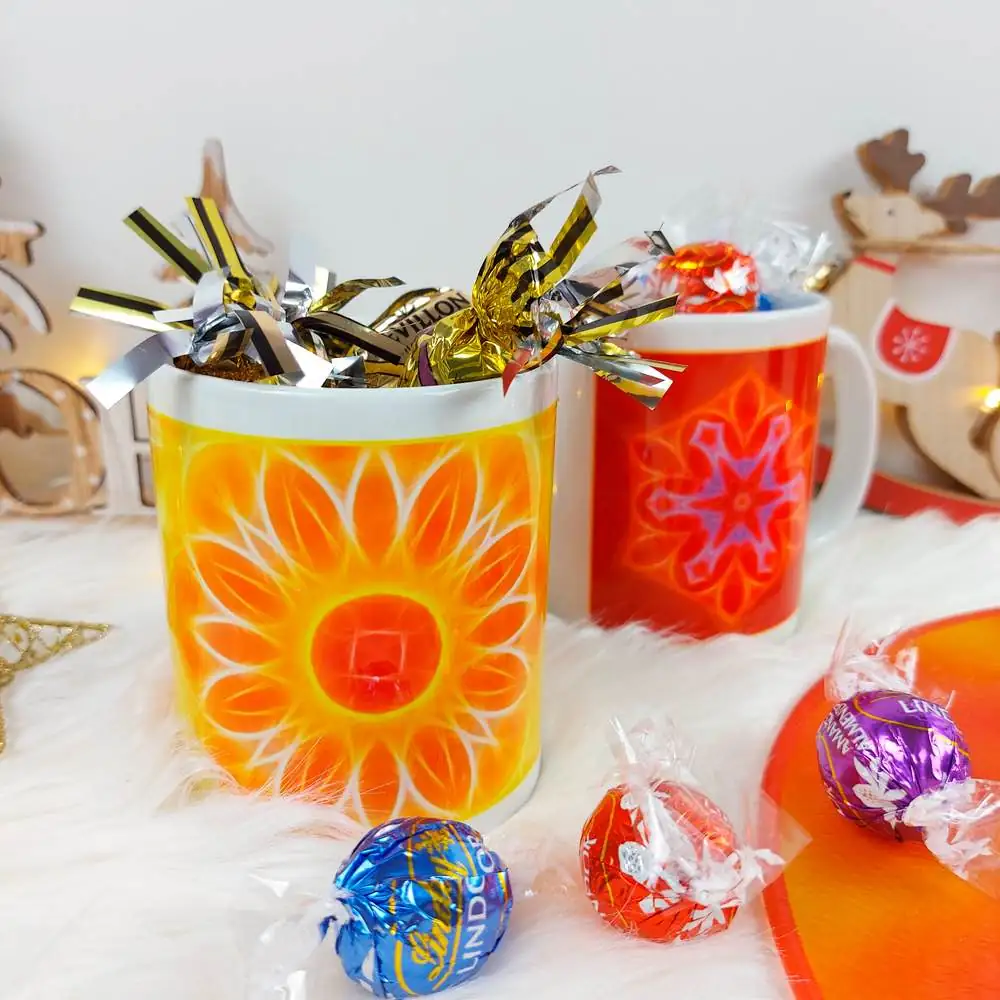 Mandala mugs filled with chocolates wrapped in foil, symbolizing the sweetness, warmth, and conviviality of the holiday season