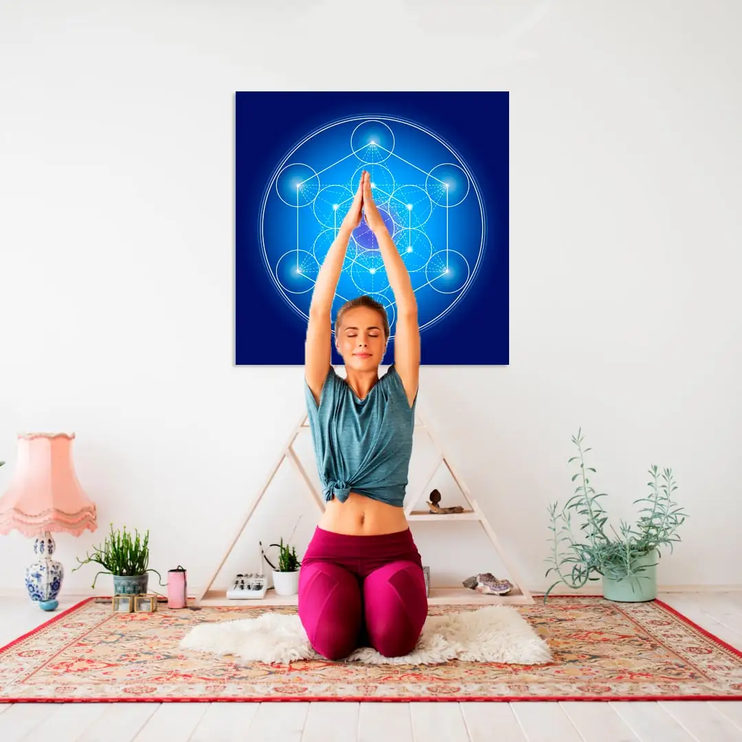 Woman meditating in front of a blue Metatron's Cube canvas, a sacred geometry symbol for raising vibrational frequency