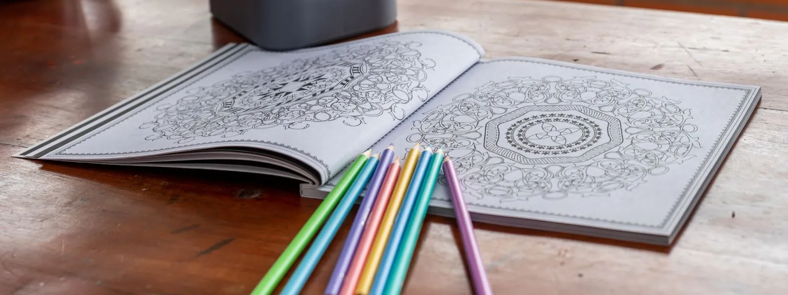 An open mandala coloring book with crayons, symbolizing creativity, relaxation, and the benefits of art therapy for children and adults