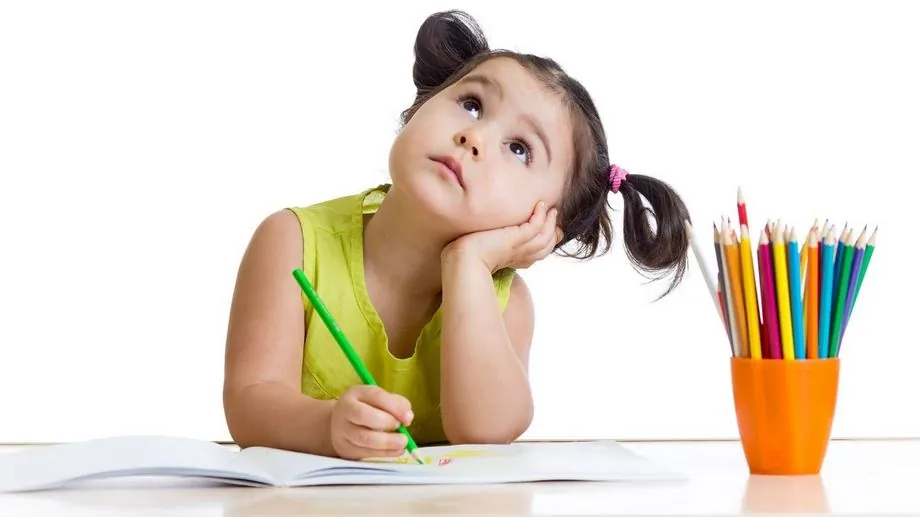 Niña dibujando y mirando al cielo, simbolizando creatividad, concentración y escape mental en un momento de reflexión