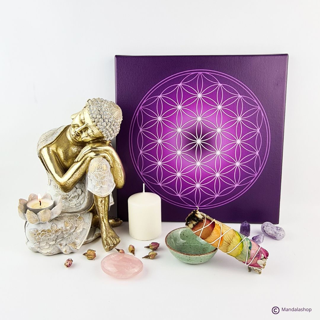 Sacred space with flower of life canvas, sage stick, Buddha statue, candle and stones, promoting harmony and connection with the symbol.
