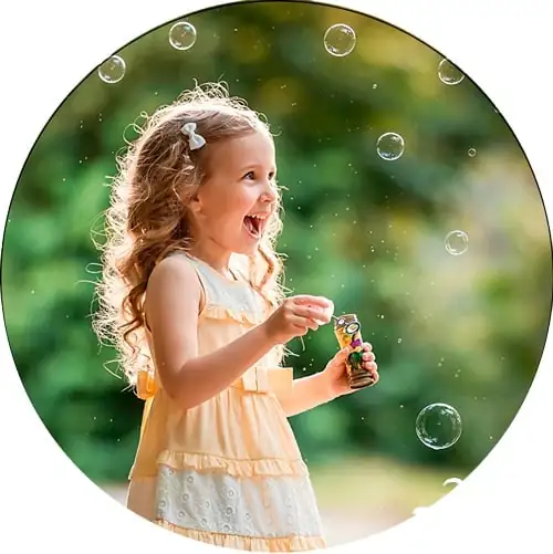 A little girl blowing soap bubbles, symbolizing the joy of life, innocence, and lightness of childhood