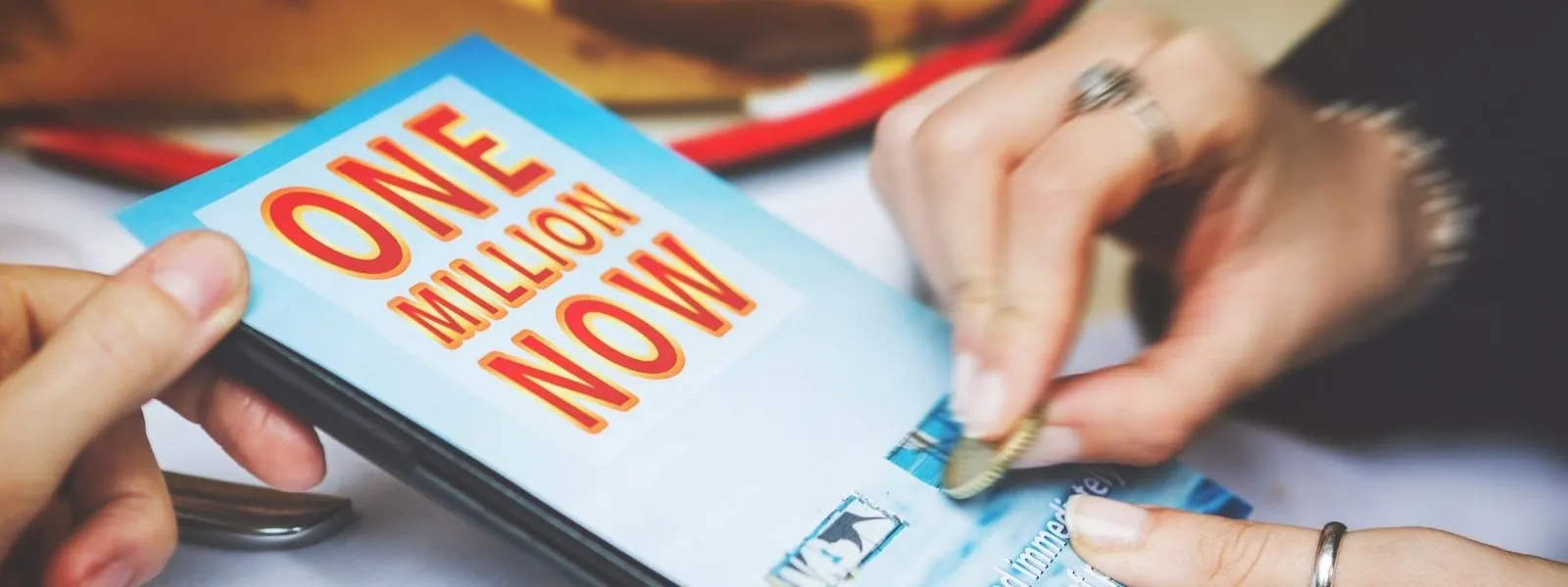 Person, die ein Glücksspiel freirubbelt, symbolisiert Hoffnung, Glück und die Möglichkeit zu gewinnen