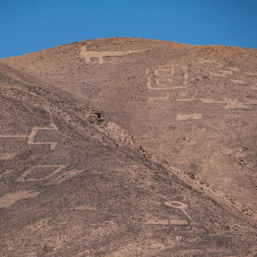 Photo d’un géoglyphe ancien au Chili, représentant une figure symbolique gravée dans le sol du désert