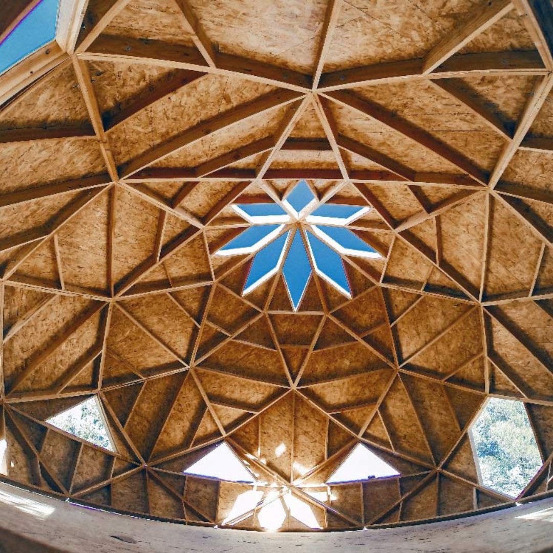 Toit en étoile d’un zome Alterhabitat vu du dessous, structure géométrique inspirée