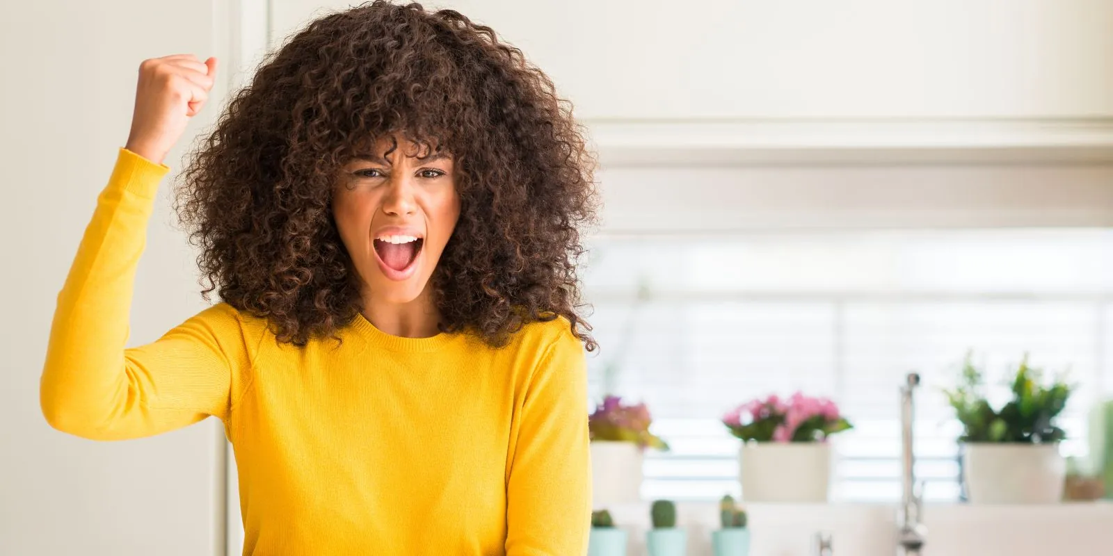 Mujer enojada gritando y levantando el puño, ilustrando el desafío de mantener la calma frente a la ira y las emociones intensas