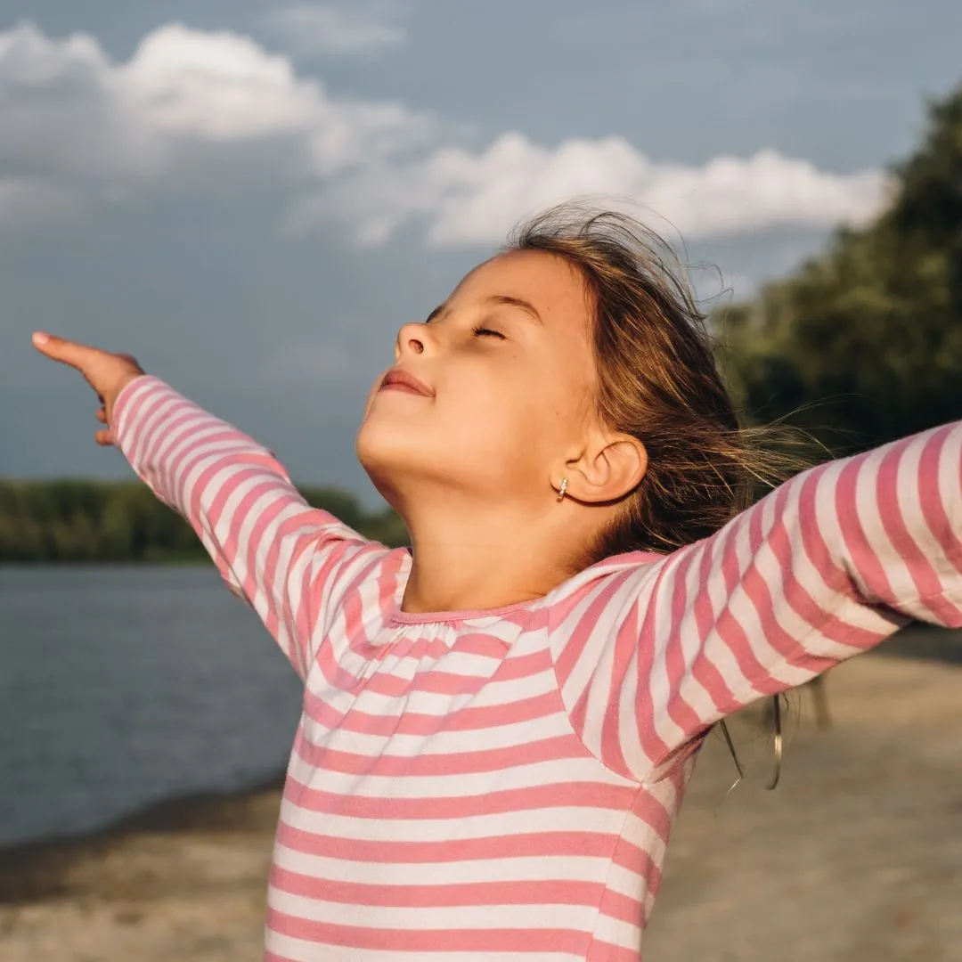 Niña practicando respiración profunda, usando esta técnica para centrarse, calmar su mente y reducir el estrés
